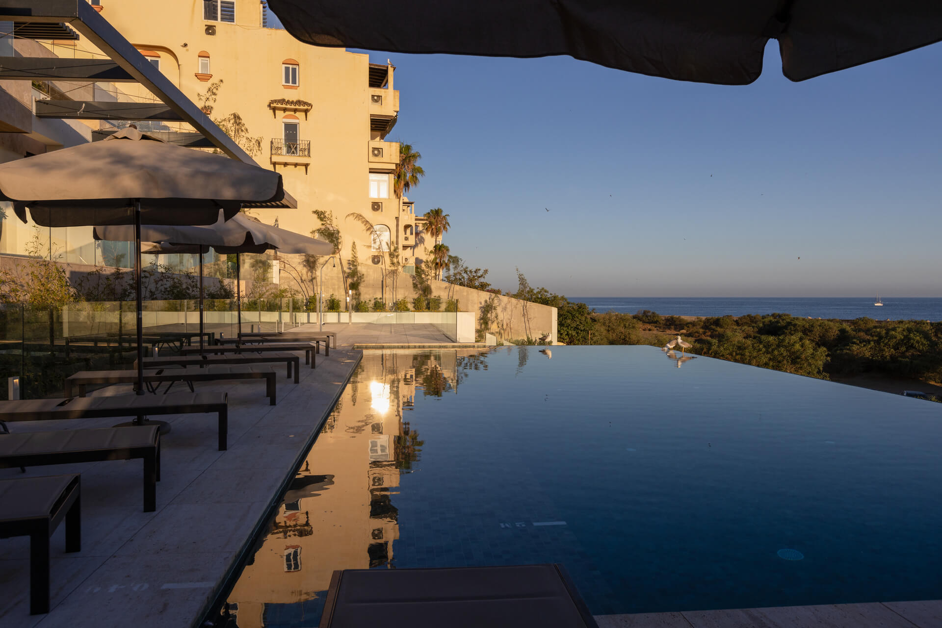 Het gebouw van Ikkil Bay met infinity pool bij zonsondergang